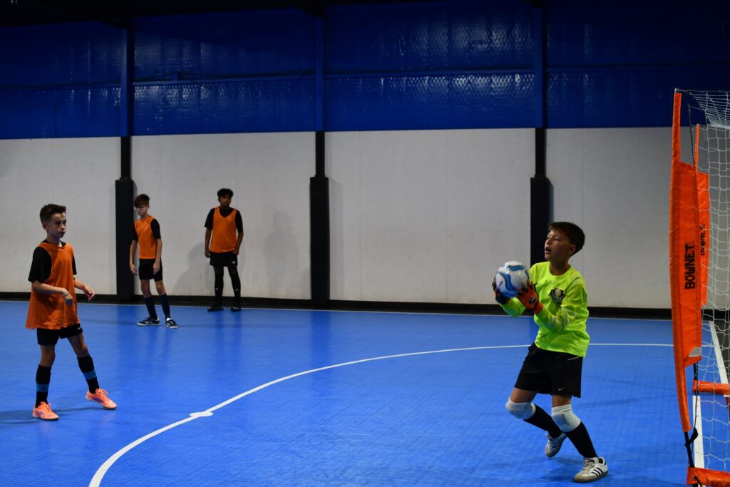 Joga Labs youth futsal goalkeeper making a save at practice near Trophy Club, TX
